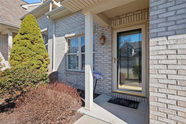 doorway to property with brick siding