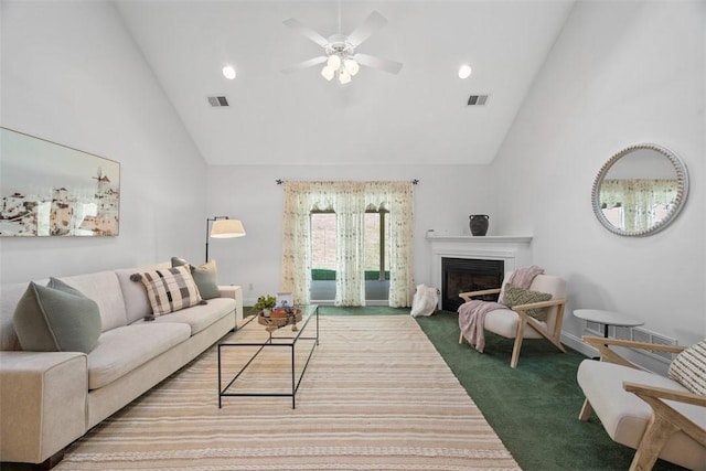 carpeted living room with high vaulted ceiling, a fireplace, visible vents, and ceiling fan