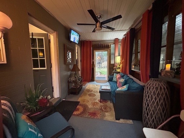 living area featuring a ceiling fan and wood ceiling