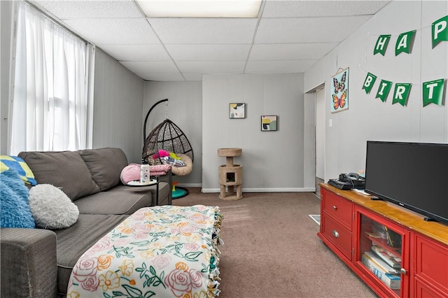 living room featuring a paneled ceiling, baseboards, and carpet floors