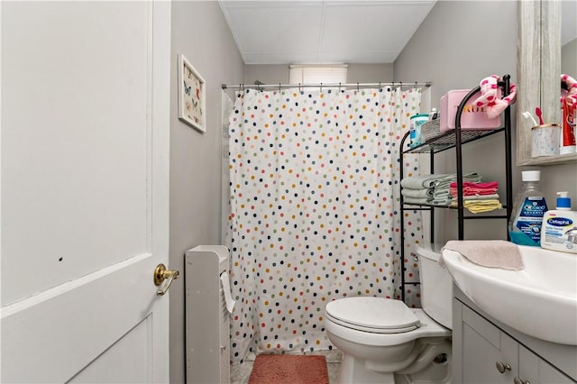 bathroom with curtained shower, toilet, and vanity