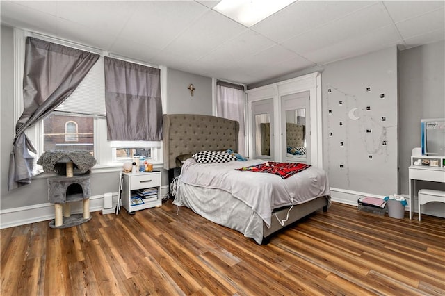 bedroom with baseboards and wood finished floors