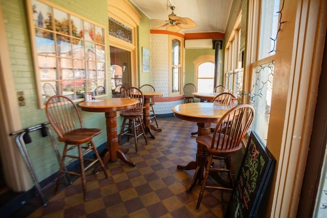 dining room with dark floors, a ceiling fan, and a wall mounted AC