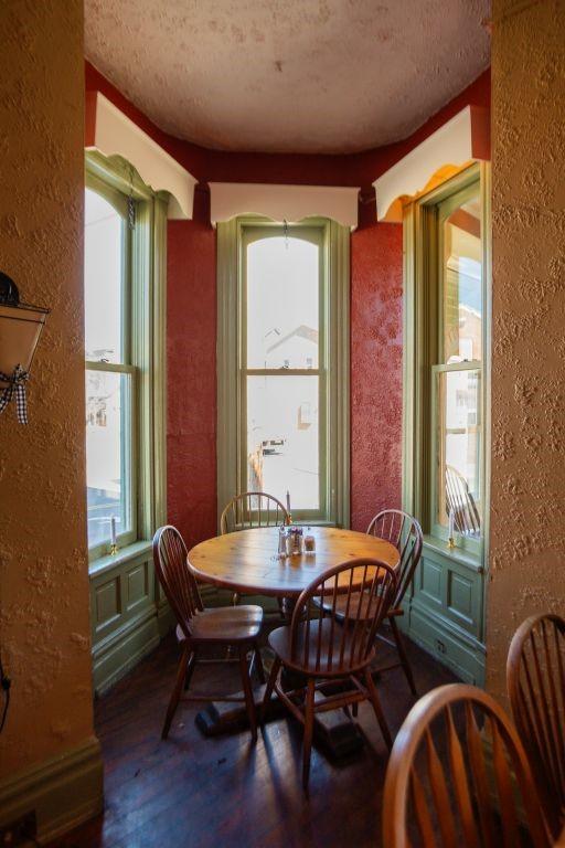 dining room featuring wood finished floors, a textured ceiling, and a textured wall