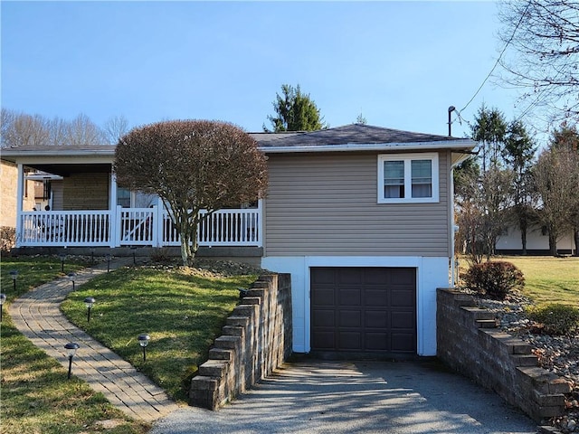 view of front of property with a porch, an attached garage, a front yard, and driveway