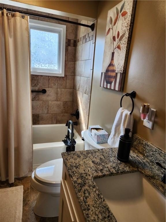 bathroom featuring toilet, vanity, and shower / bathtub combination with curtain