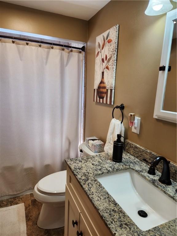 full bath with toilet, vanity, and a shower with shower curtain