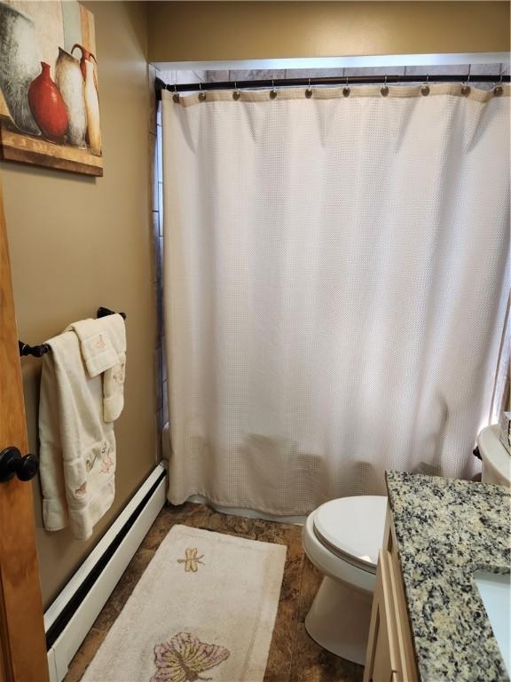 bathroom with a baseboard heating unit, toilet, and vanity