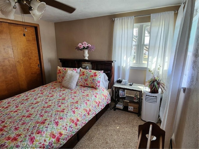 carpeted bedroom with a textured ceiling and a ceiling fan