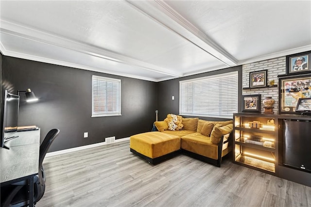 living area with beam ceiling, visible vents, baseboards, and wood finished floors