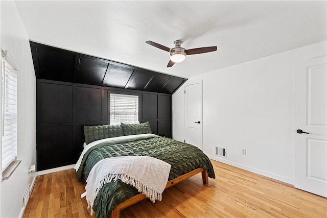 bedroom with visible vents, baseboards, lofted ceiling, ceiling fan, and light wood-style floors