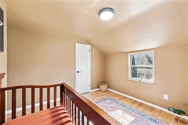 bedroom featuring baseboards, lofted ceiling, and wood finished floors