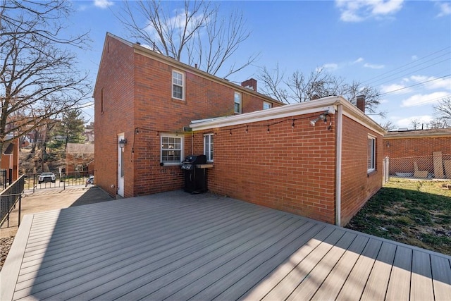 deck with a grill and fence