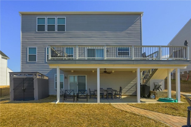 rear view of house featuring a ceiling fan, a yard, an outbuilding, a storage unit, and a patio