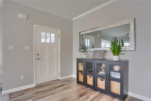 entrance foyer featuring baseboards, wood finished floors, and crown molding