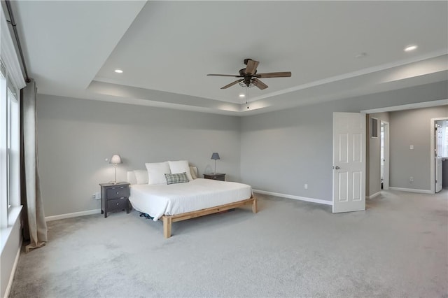 unfurnished bedroom featuring a tray ceiling, recessed lighting, carpet, and baseboards