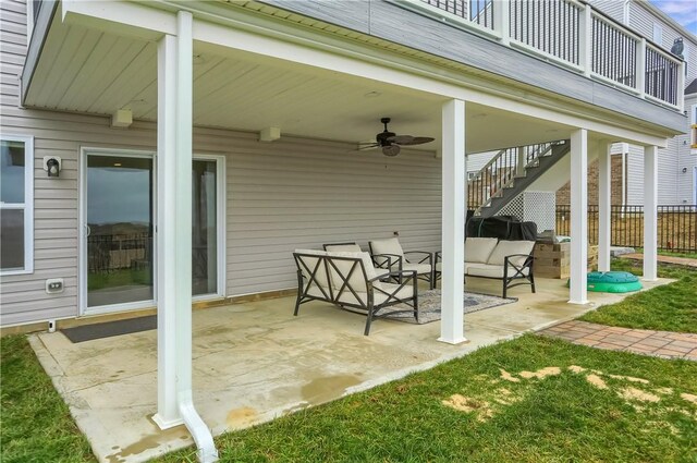 view of patio featuring outdoor lounge area, a ceiling fan, stairs, and fence