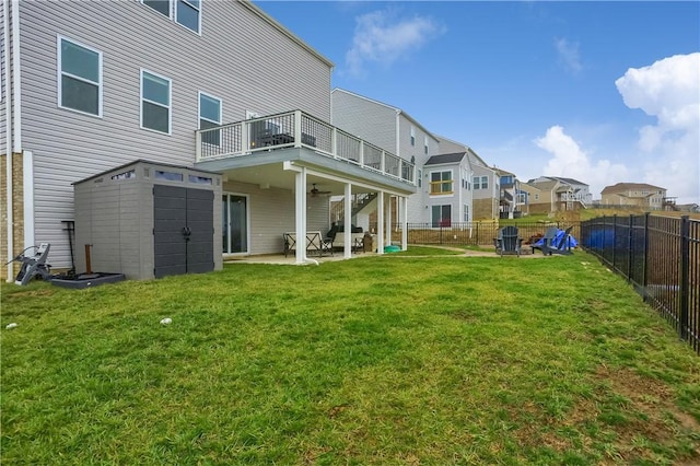 back of property featuring a lawn, a fenced backyard, a ceiling fan, and a patio area