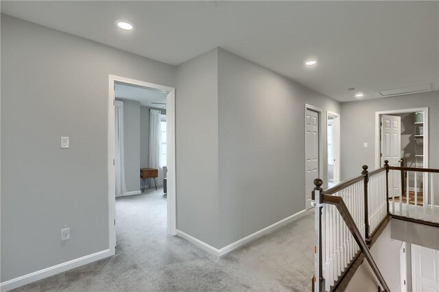 corridor with recessed lighting, baseboards, an upstairs landing, and carpet flooring