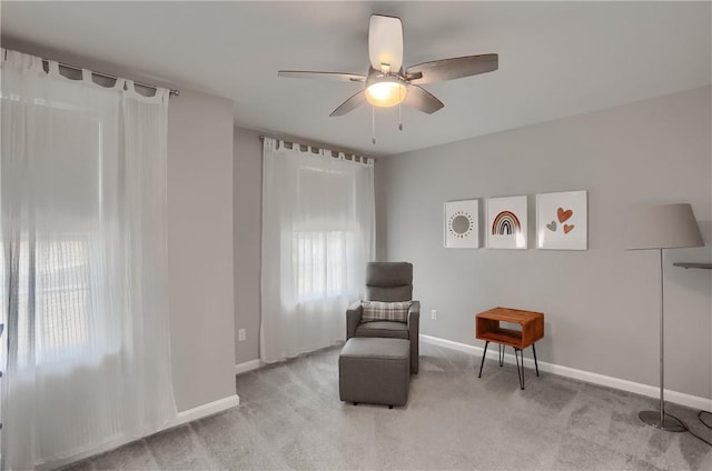 sitting room featuring ceiling fan, baseboards, and carpet floors