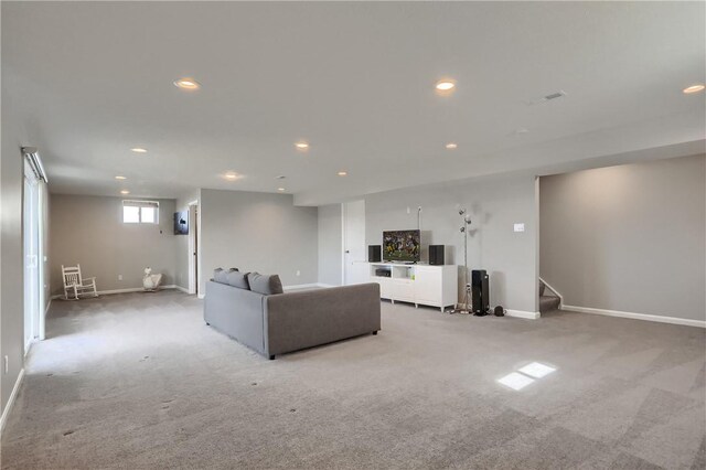 unfurnished living room featuring recessed lighting, light colored carpet, and stairs