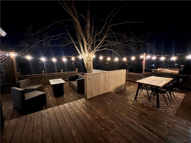 deck at night with outdoor dining space