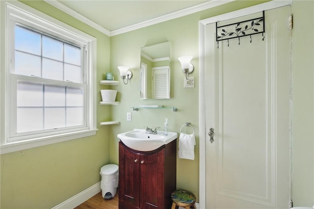 bathroom featuring vanity, crown molding, baseboards, and wood finished floors