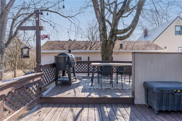 deck with outdoor dining area and a grill