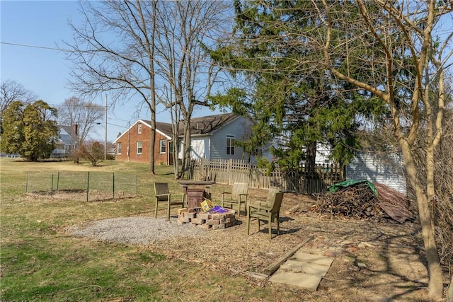 view of yard with fence and an outdoor fire pit