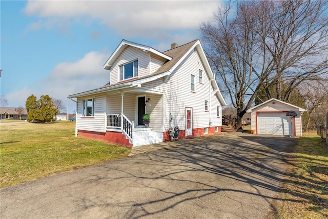 view of front of property with an outbuilding, driveway, a front lawn, a detached garage, and a porch