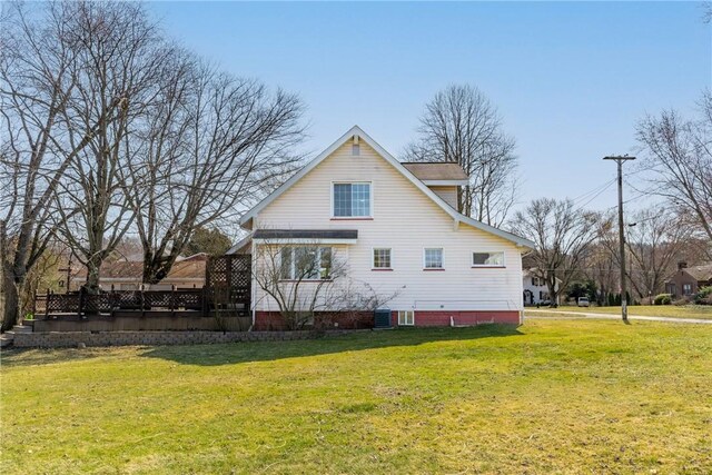 rear view of property featuring a lawn and central AC