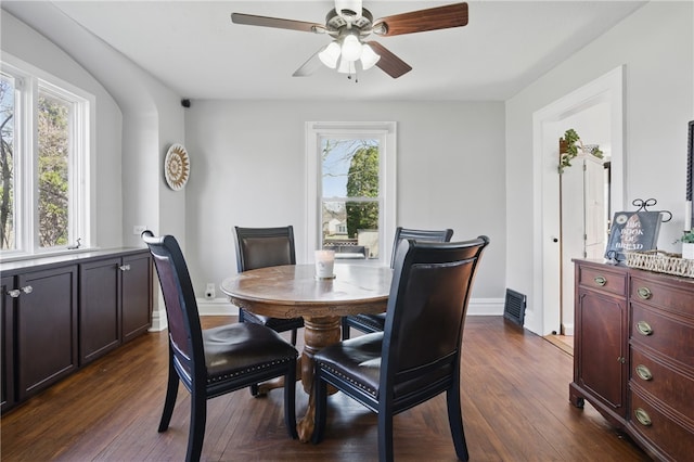 dining space with dark wood-style floors, baseboards, and ceiling fan