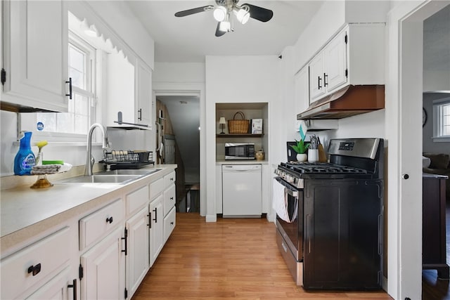 kitchen featuring a sink, stainless steel appliances, light countertops, under cabinet range hood, and white cabinetry