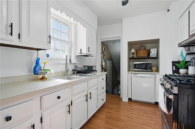 kitchen with a sink, appliances with stainless steel finishes, white cabinets, and light countertops