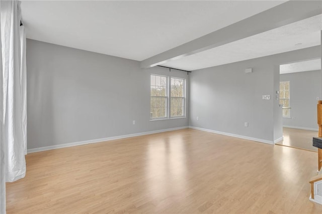 unfurnished living room with baseboards and light wood-type flooring