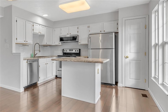 kitchen featuring a sink, stainless steel appliances, plenty of natural light, and visible vents