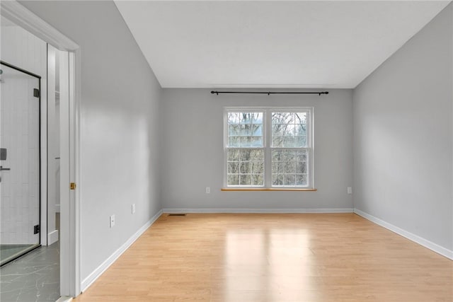 empty room with light wood-type flooring and baseboards