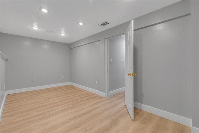 basement featuring light wood finished floors, visible vents, recessed lighting, and baseboards