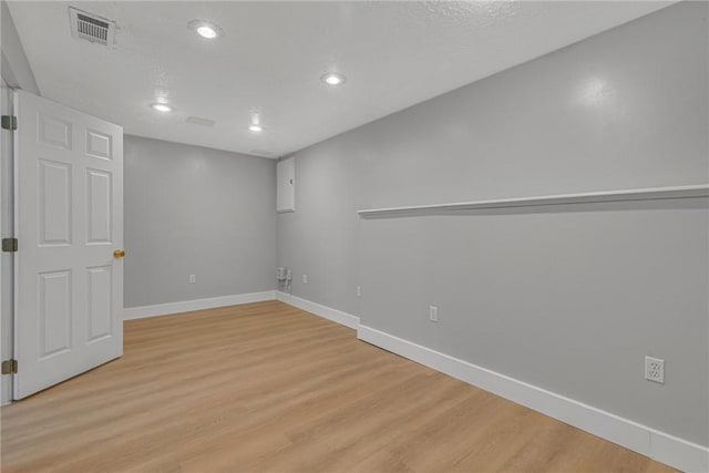 below grade area with recessed lighting, visible vents, baseboards, and light wood-style floors