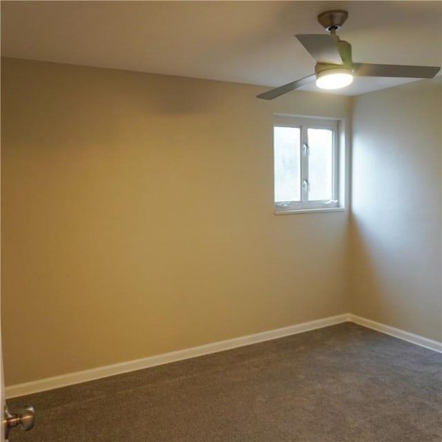 spare room with baseboards, a ceiling fan, and dark carpet