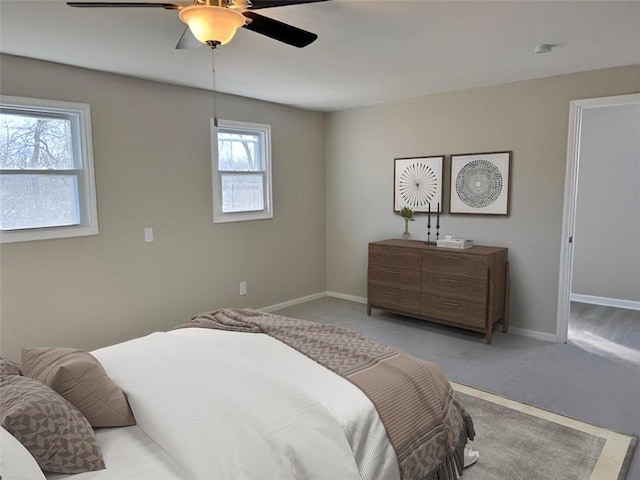 carpeted bedroom with ceiling fan and baseboards