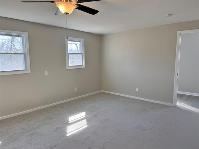 spare room with carpet flooring, baseboards, and ceiling fan