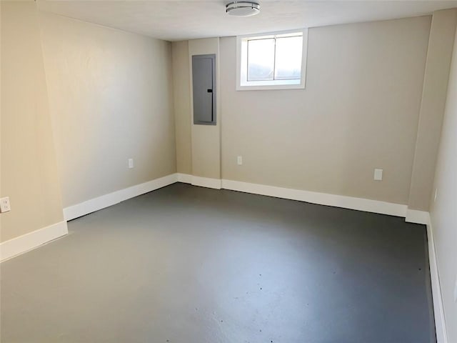 spare room featuring electric panel, baseboards, and finished concrete floors