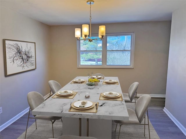 dining room with dark wood finished floors, a notable chandelier, and baseboards