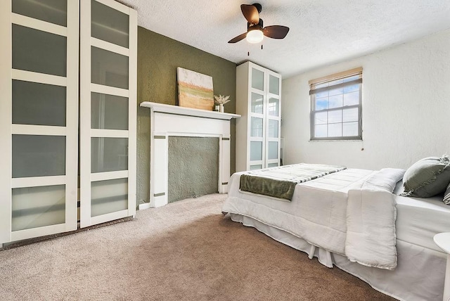 carpeted bedroom featuring a textured ceiling, ceiling fan, and a textured wall