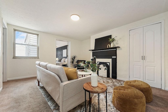 carpeted living area with a fireplace, baseboards, and a textured ceiling