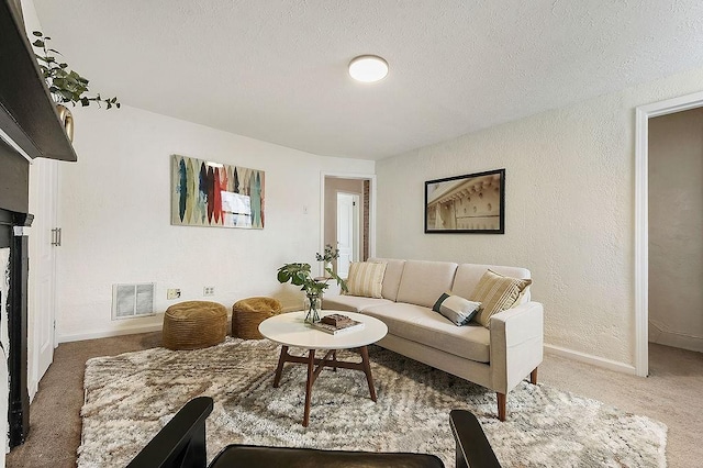 living room featuring carpet flooring, a textured wall, visible vents, and a textured ceiling