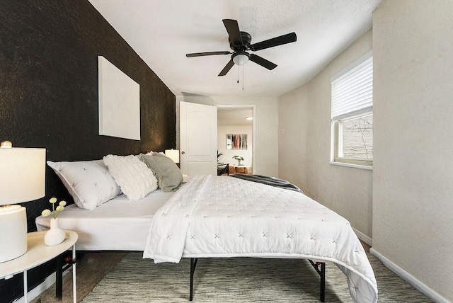 bedroom with a ceiling fan and baseboards