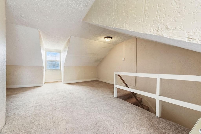 bonus room featuring vaulted ceiling, carpet floors, and a textured ceiling