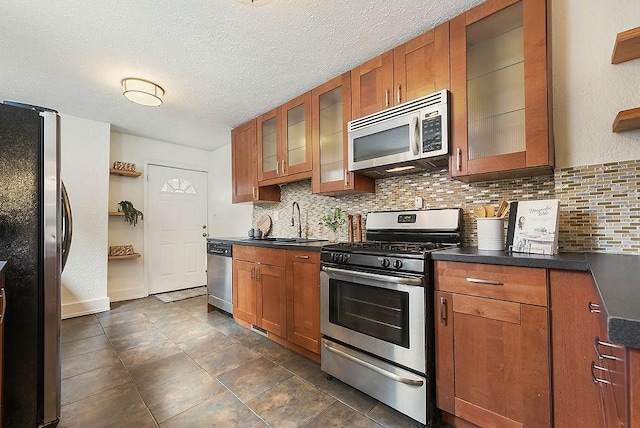 kitchen with open shelves, a sink, decorative backsplash, stainless steel appliances, and brown cabinets